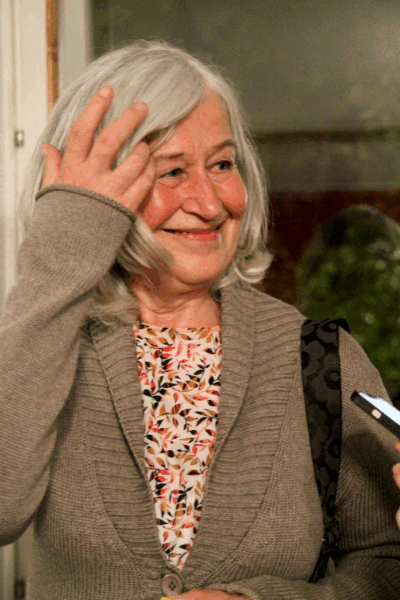 Åsa Tuohimetsä i en brun cardigan och en blommig tröja. Hon tittar leende till sidan.