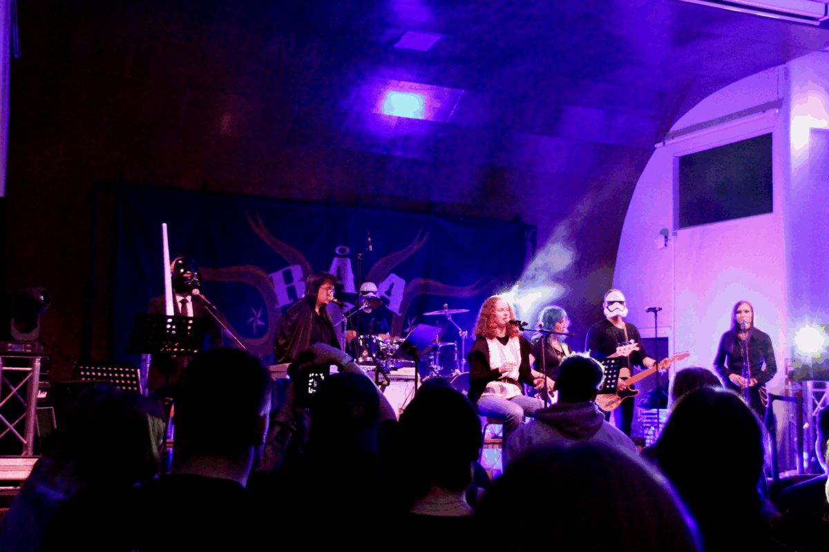 Ett band på scen. Sångaren är klädd som Luke Skywalker, medan resten av bandet är klädda som Stormtroopers, Darth wader eller någon annan jedi.