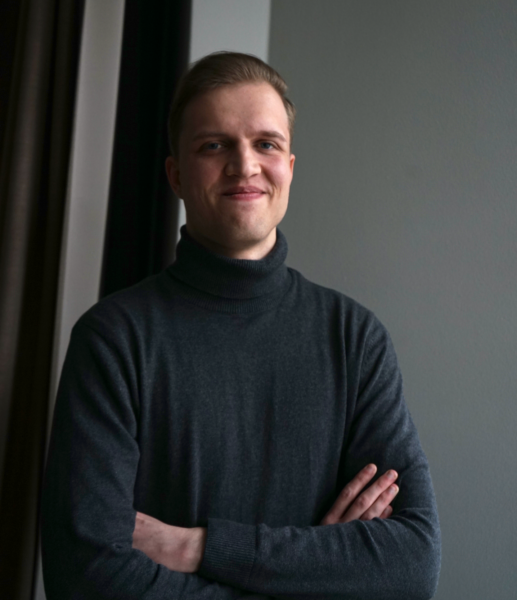 Emil Aarnio ser leende in i kameran. Han har armarna i kors.