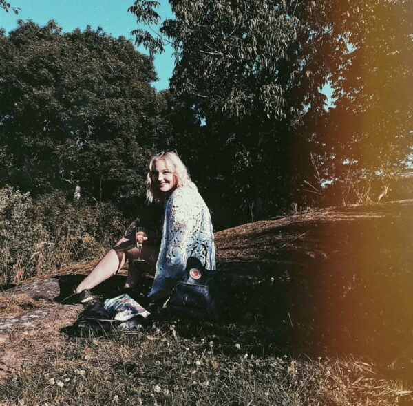 Natalie Skogman sitter på en klippa i solsken.