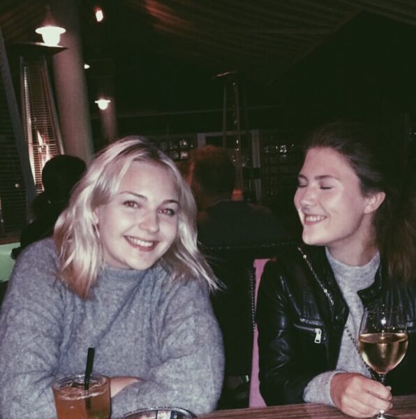 Natalie Skogman och hennes vän sitter vid ett bord med varsitt glas vin.